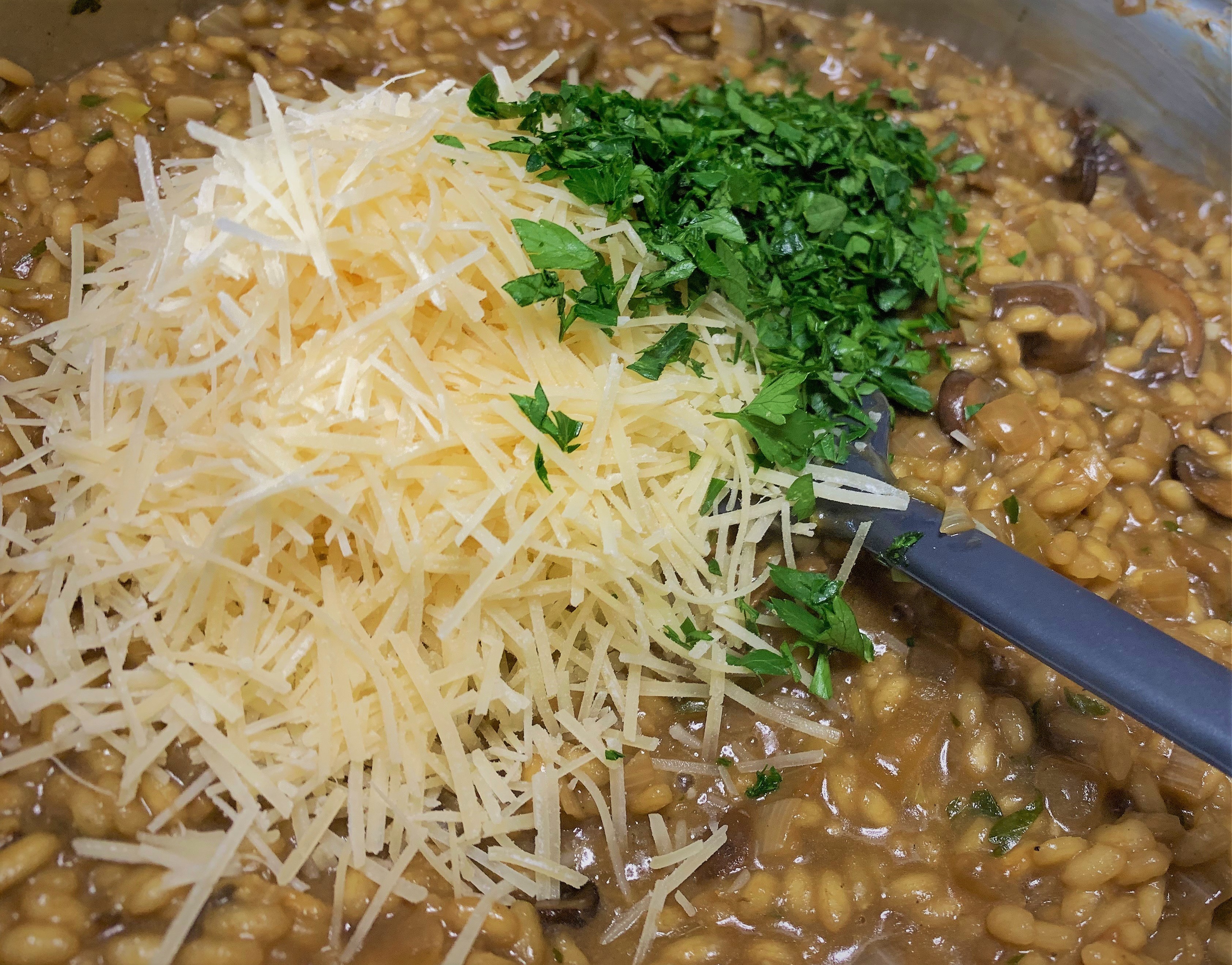 Adding the Parmesan Cheese and Parsley to our cooked Wild Mushroom Risotto