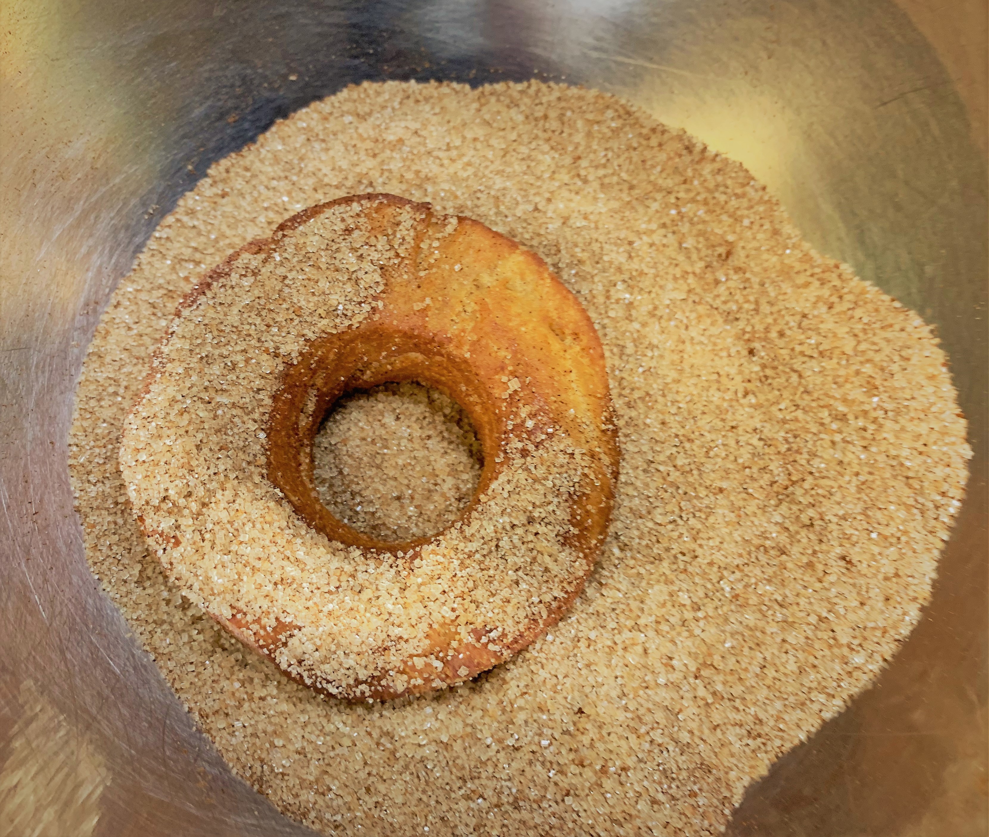 Tossing the doughnuts in cinnamon sugar