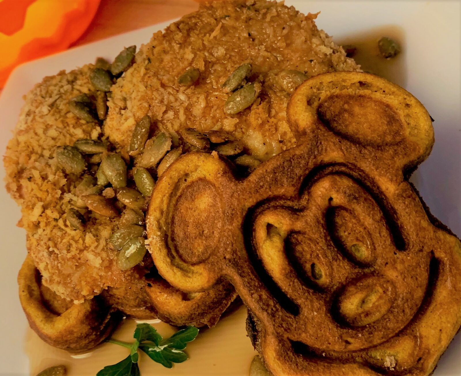 Our plated Pumpkin Mickey Waffles with Oven "Fried" Chicken and Candied Pumpkin Seeds