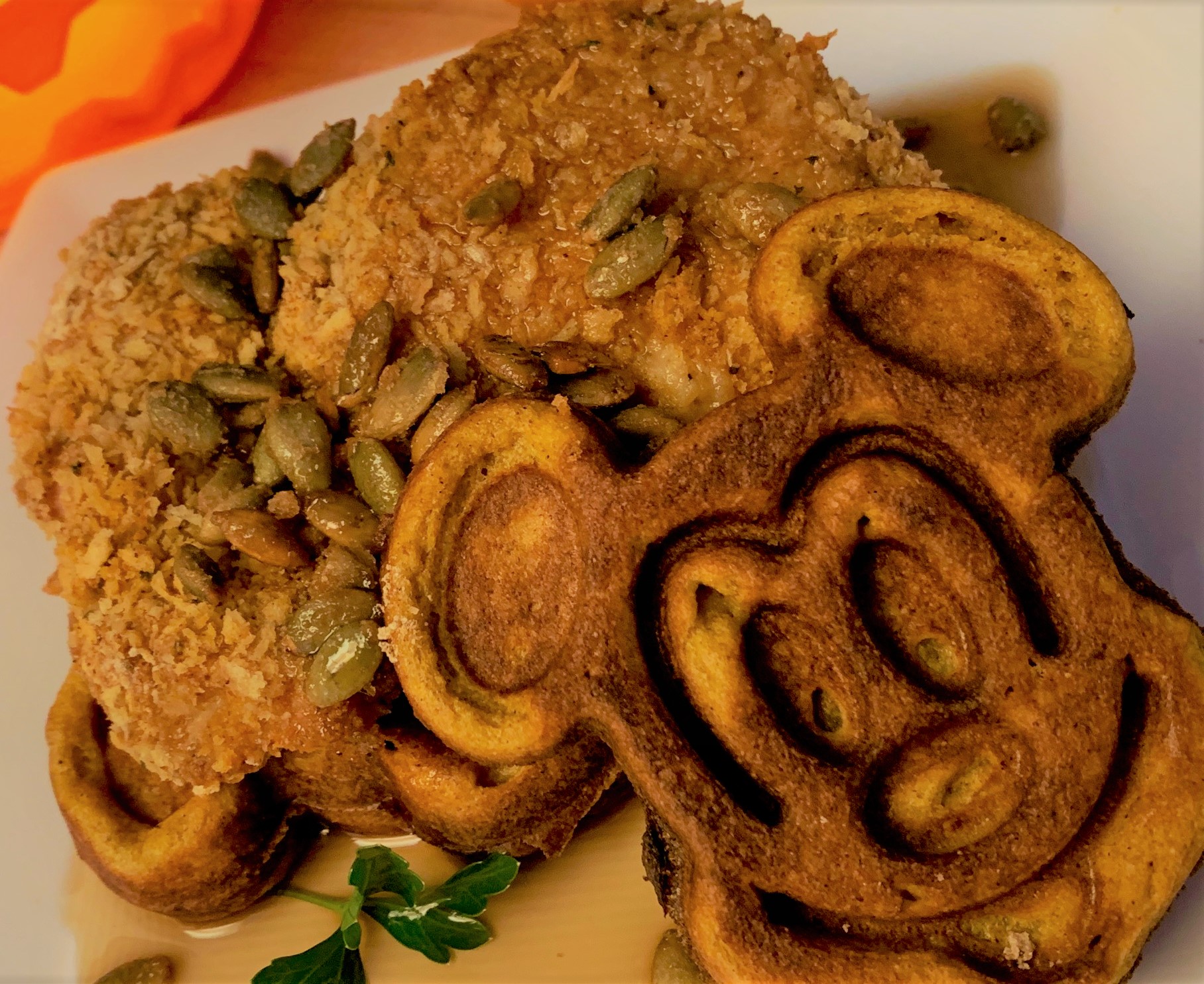 Our plated Pumpkin Mickey Waffles with Oven "Fried" Chicken and Candied Pumpkin Seeds