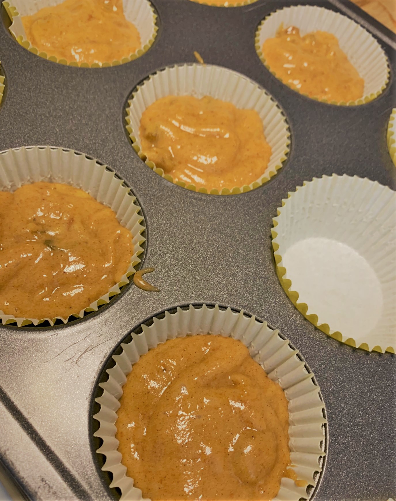 Adding our Pumpkin Muffin Batter to our pan