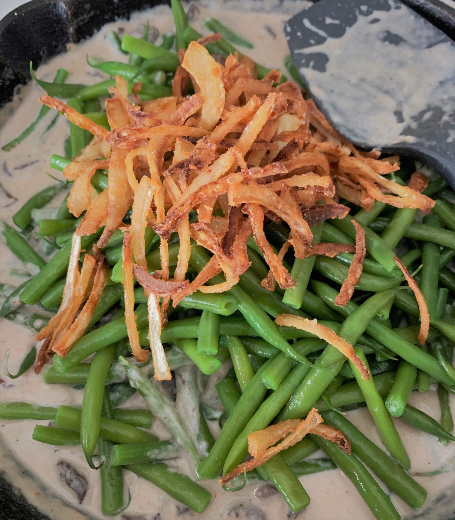 Adding our green beans and fried onions to our dish