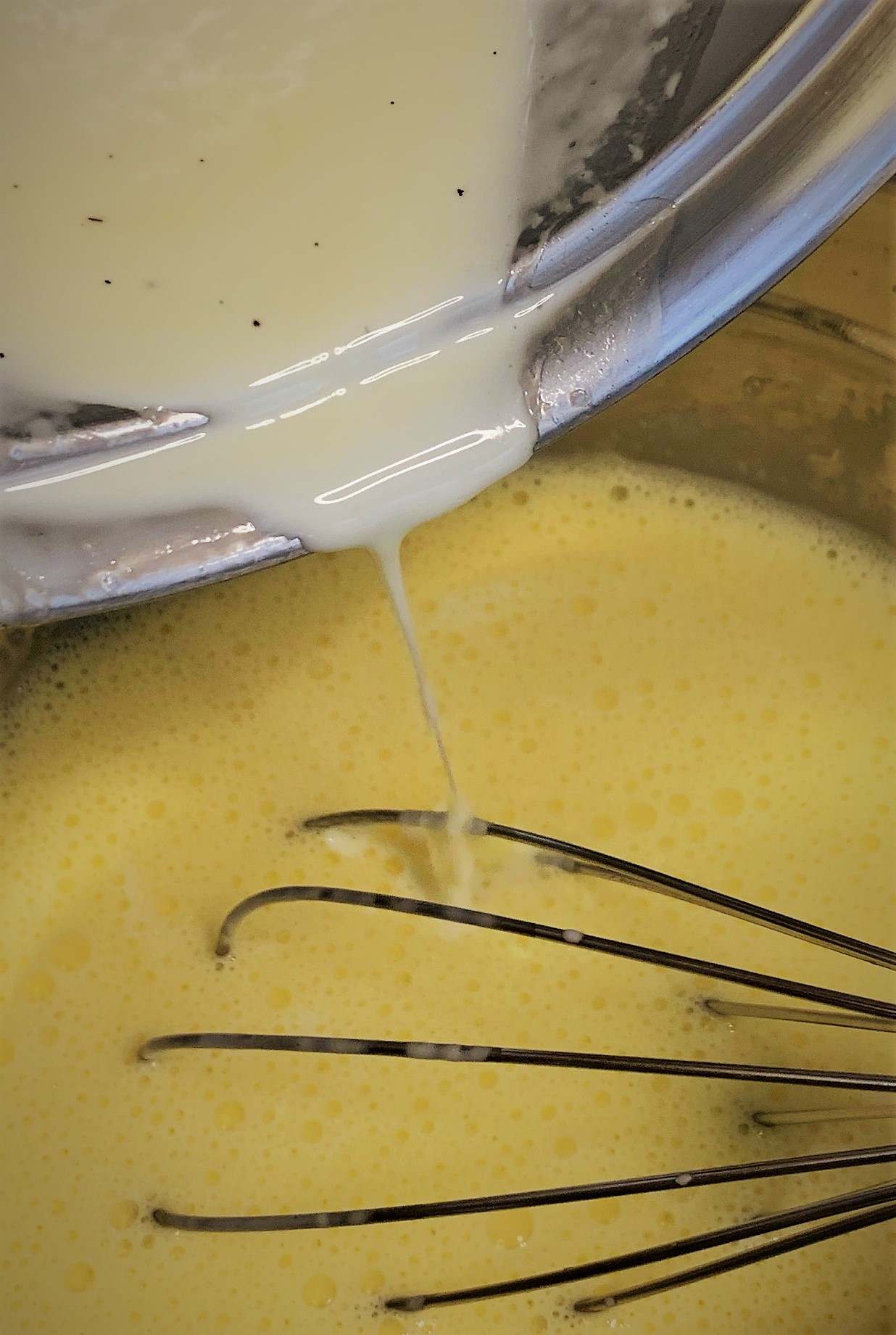 Adding the heated Heavy Cream to our Egg Yolks for the Vanilla Sauce