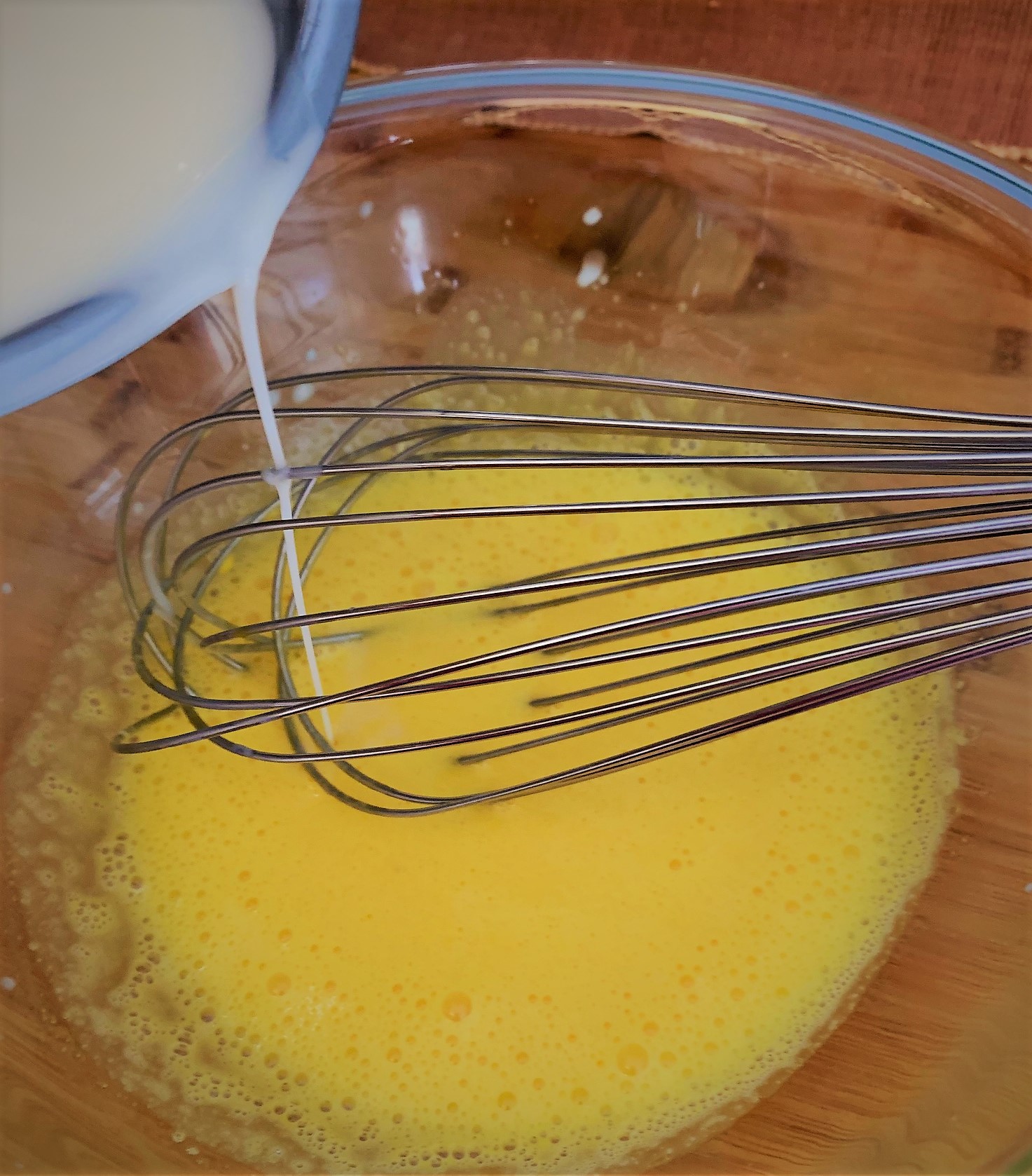 Adding the heated Cream Mixture to the whipped Egg Yolks