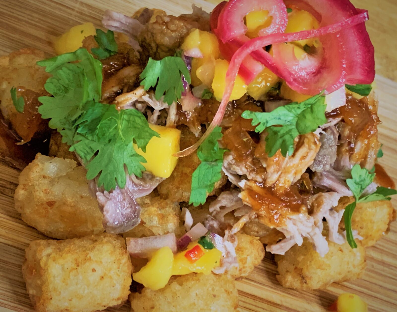 Our fully plated Kalua-Style Pulled Pork Tots with Polynesian BBQ Sauce & Mango Salsa