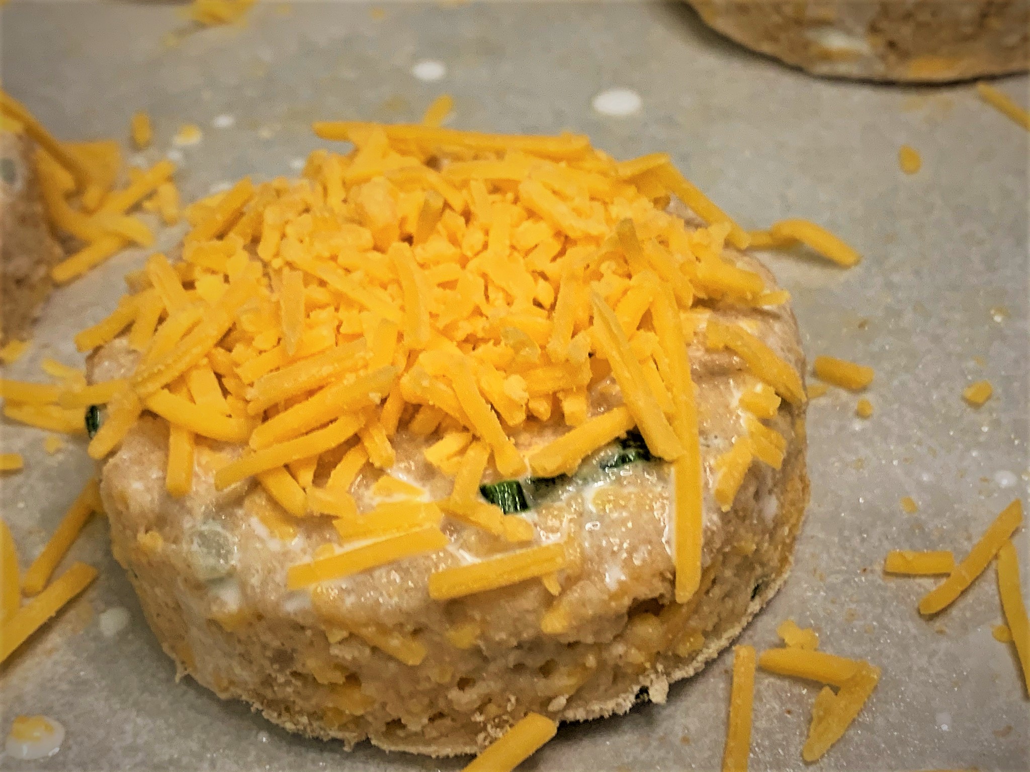 Adding Cheese to the top of the Biscuits