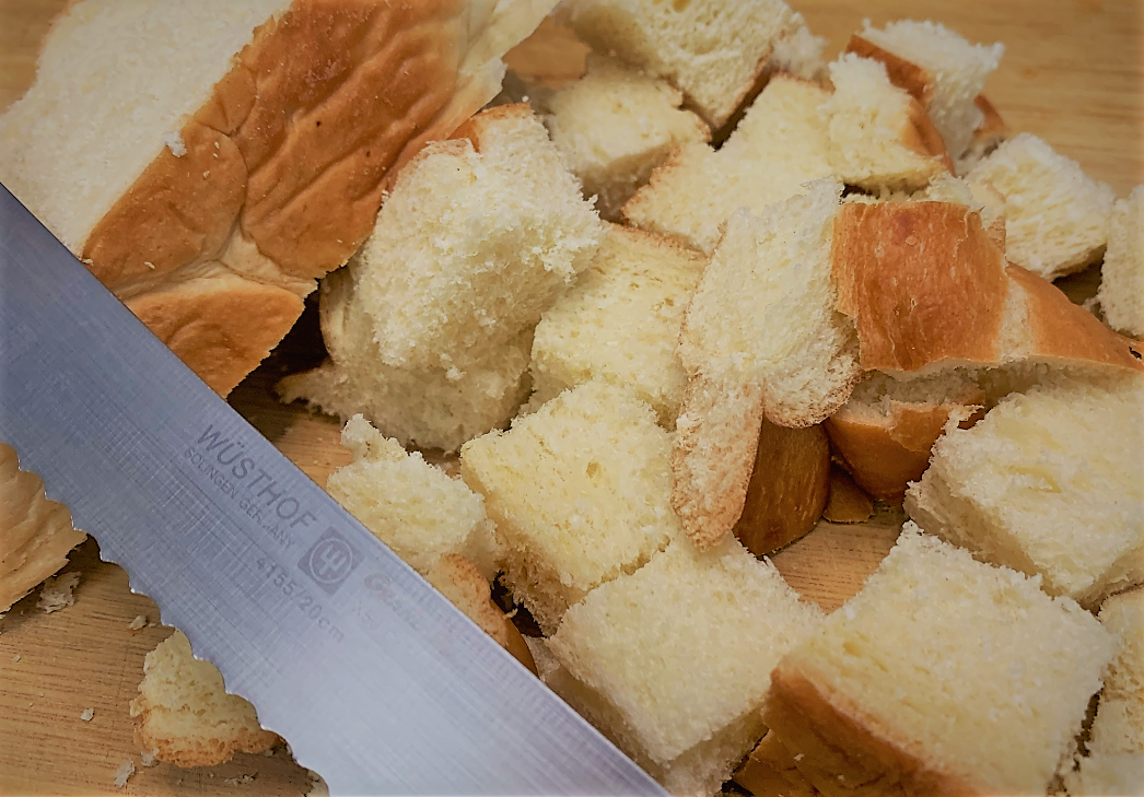 Cubing the Bread for our Boma French Toast Bread Pudding with Pecan Praline Sauce