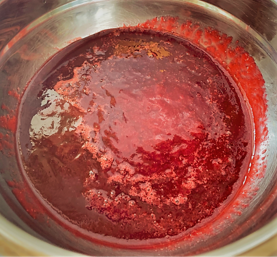 Straining the Raspberry Purée for our Disney Dishes Piña Colava Recipe