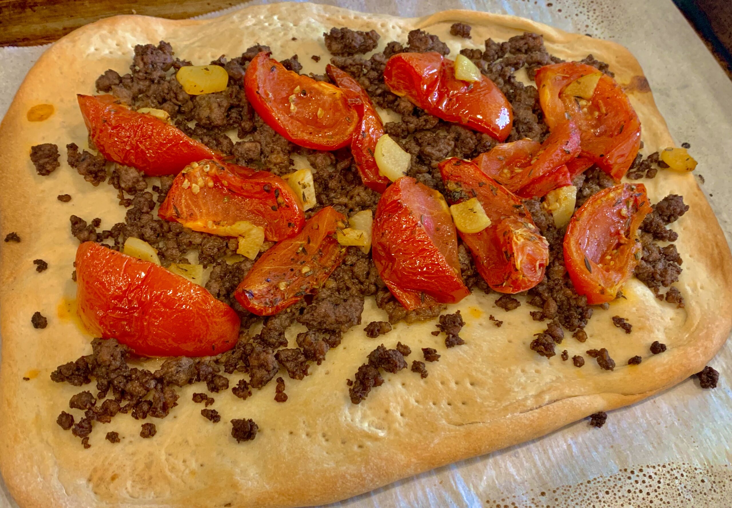 The fully baked flatbread dough with "meat" and roasted tomatoes