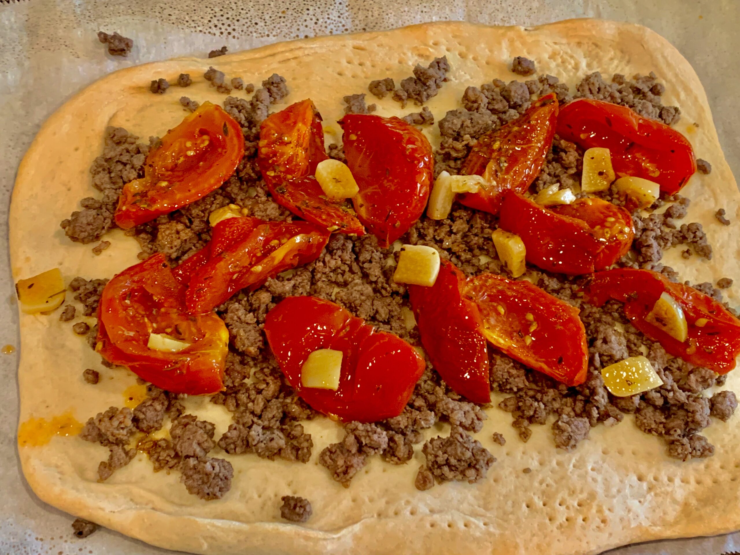 Roasted tomatoes and garlic added to the top of our flatbread crust