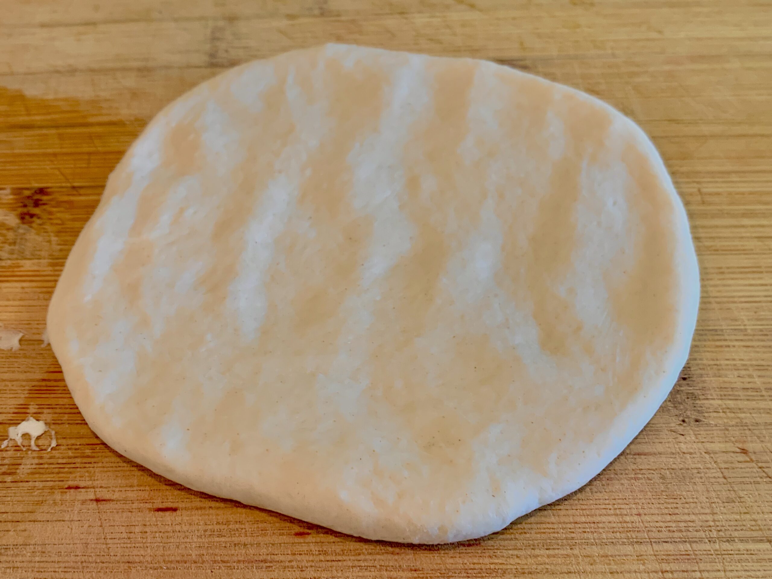 Flattened dough portion ready for baking